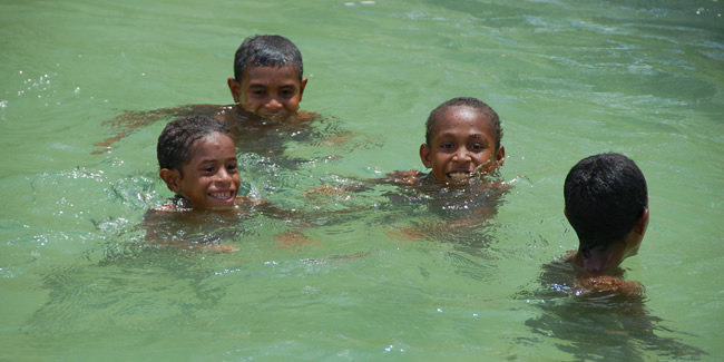 Zwemmende kinderen bij Soepiori, een van de Schouteneilanden.
